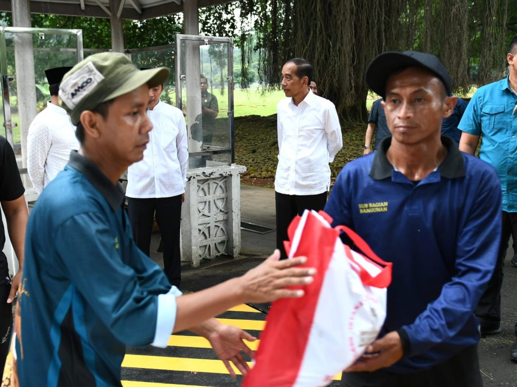 Presiden Jokowi menyaksikan penyerahan bantuan paket sembako bagi masyarakat di sekitar Kompleks Istana Kepresidenan Bogor, Jawa Barat.